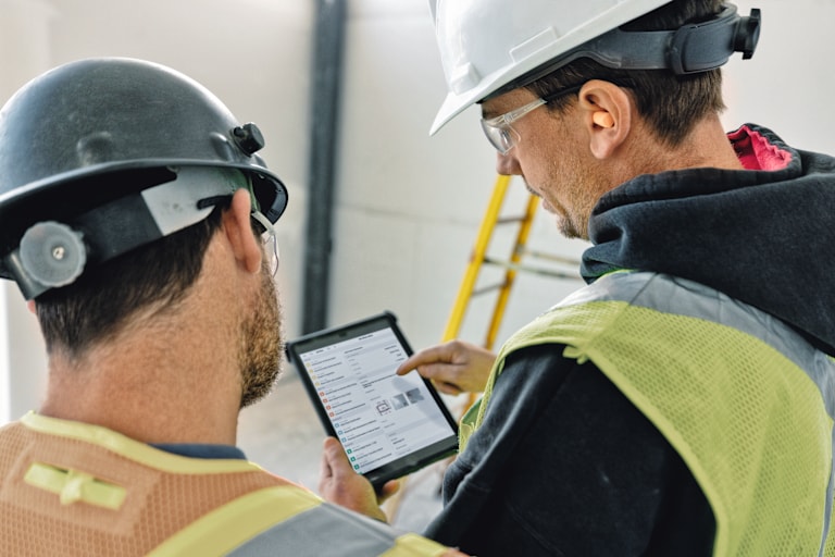 Responsable des opérations et ouvrier sur chantier utilisant une tablette avec Fieldwire