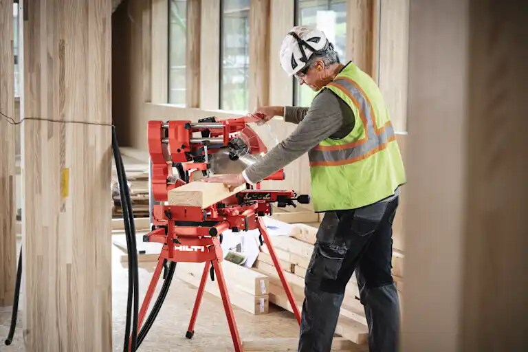 Application picture of the cordless miter saw SM 60-22 attached to the cordless vacuum cleaner VC 4X-22. Wood cutting application. Application without gloves.
