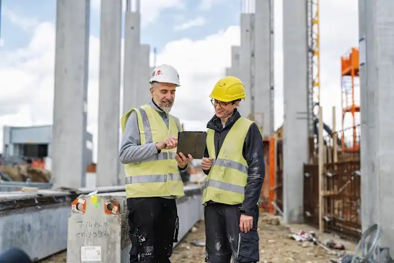 Ouvriers sur chantier examinant des plans de construction