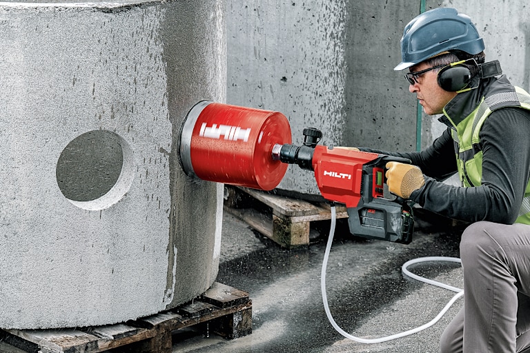 Persona arodillada perforando pared humeda con herramienta Hilti