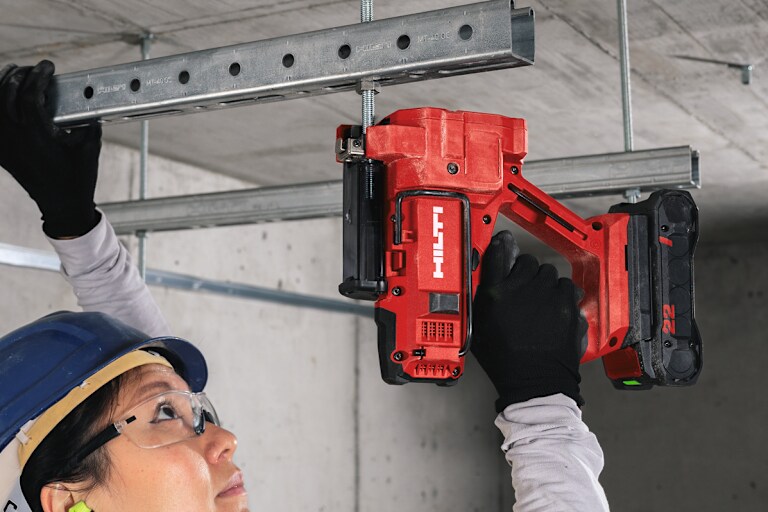 Draadstangensnijder Hilti STR 4-22 gebruikt om een bevestigingsstang voor een metalen rail aan het plafond te snijden