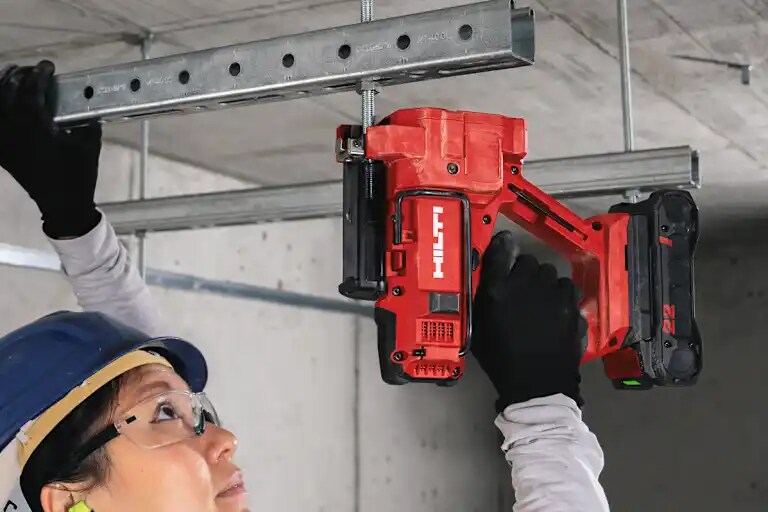 Draadstangensnijder Hilti STR 4-22 gebruikt om een bevestigingsstang voor een metalen rail aan het plafond te snijden