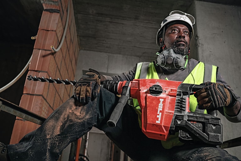 MAN USING HILTI DRILL
