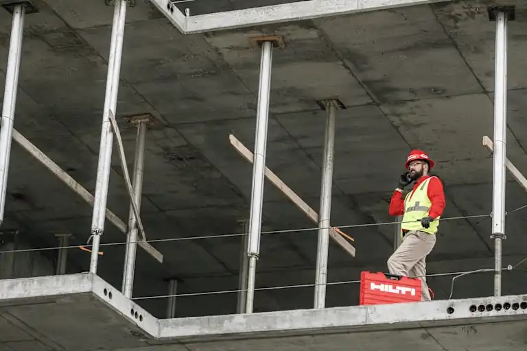 Responsable comercial de Hilti hablando por teléfono con un cliente.