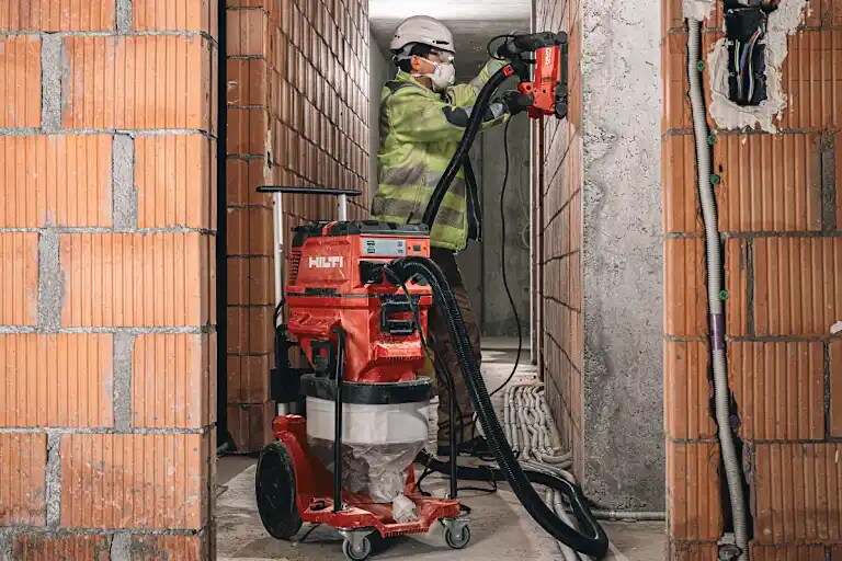 Cropped application picture of the corded vacuum cleaner 20/40/150-X with continuous bag accessory, attached to the slitting tool DCH 150-SL
