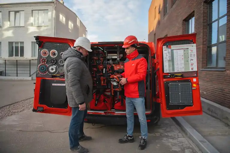 Afbeelding van klant en accountmanager bij bus