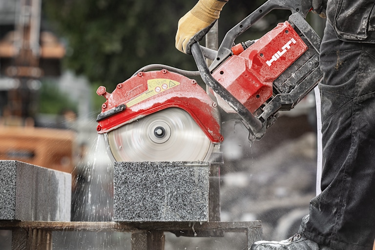 Personne utilisant une découpeuse Hilti pour couper des briques