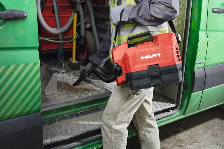 Application picture of a worker cleaning a construction van with the cordless vacuum cleaner VC 2D-22.