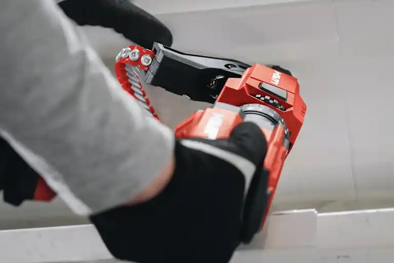 Photo d’application de la visseuse sans fil ST 2000-22, avec vis en bande SF-M3 et magasin de vis, pour une application sur plancher métallique (
