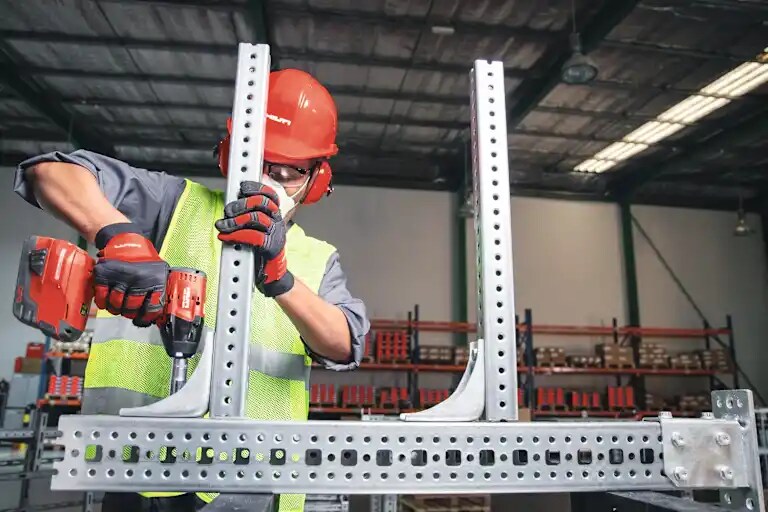 Medewerker stelt kits samen en verpakt modulaire ondersteuningssystemen