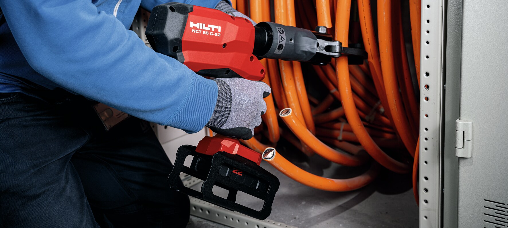 Application picture of NCT 85 C-22 hydraulic cutter with B22-55 battery cutting mid-size copper cable in panel