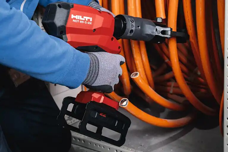 Application picture of NCT 85 C-22 hydraulic cutter with B22-55 battery cutting mid-size copper cable in panel