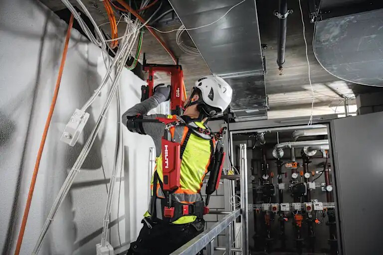 Installing cables, conduits and threaded studs overhead with the concrete nailer BX 3-22.