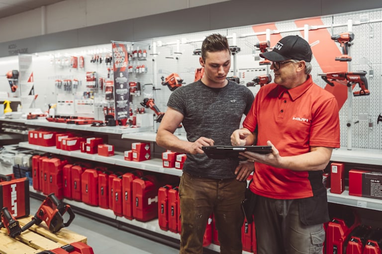 Hilti medewerker toont klant informatie op een tablet in Hilti Store