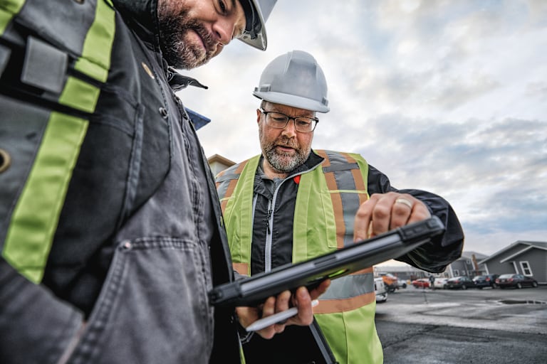 Deux employés utilisent la solution ERP 4PS sur un chantier