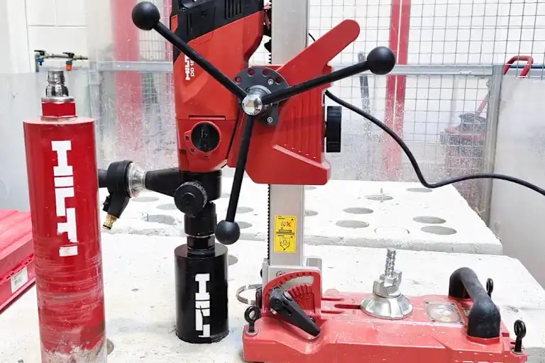 Image of the diamond coring tool DD-150 with core bits with a jobsite background for social media.