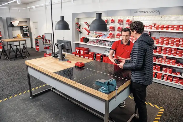 Asesor comercial de Hilti atendiendo a un cliente en una tienda Hilti Store
