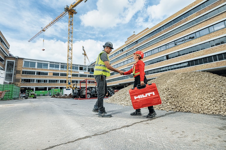 workman shaking hands with Hilti employee