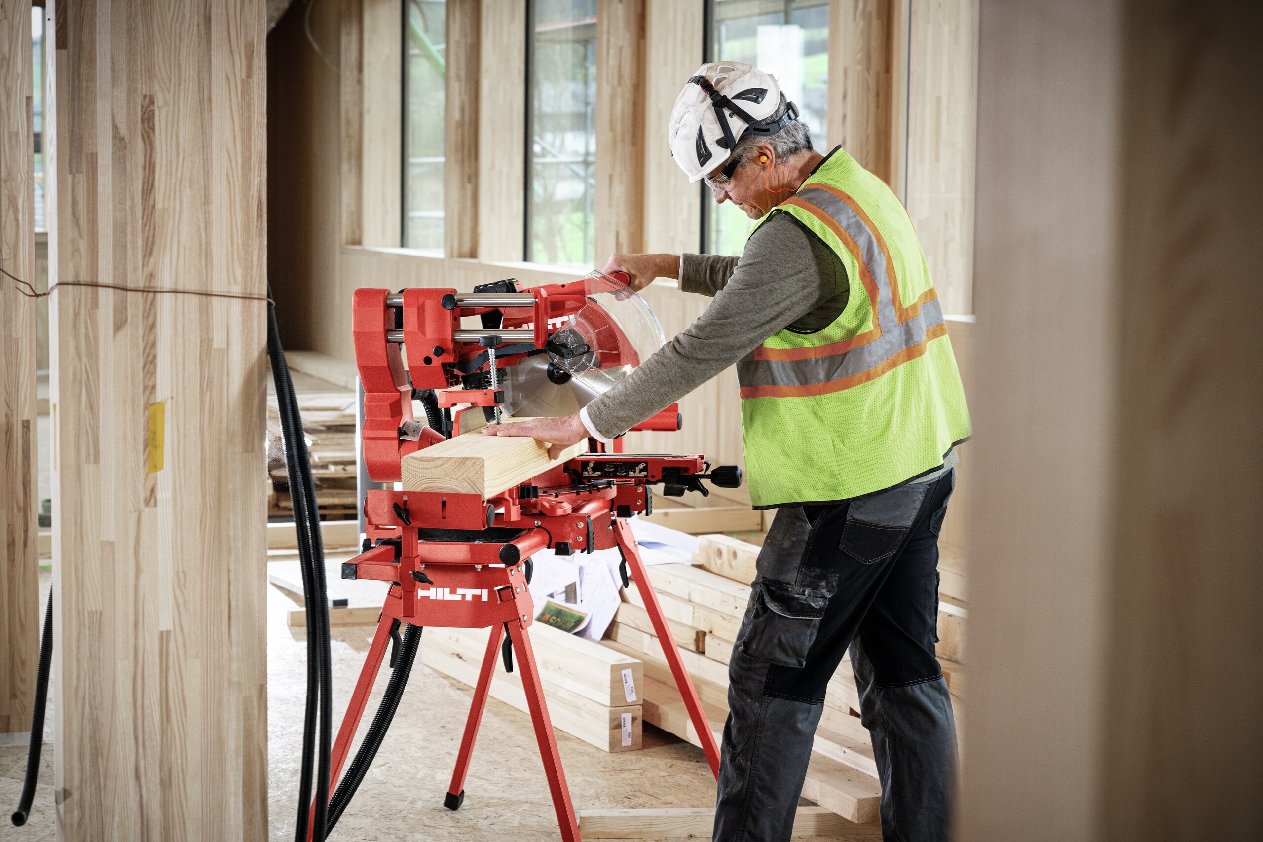 Application picture of the cordless miter saw SM 60-22 attached to the cordless vacuum cleaner VC 4X-22. Wood cutting application. Application without gloves.