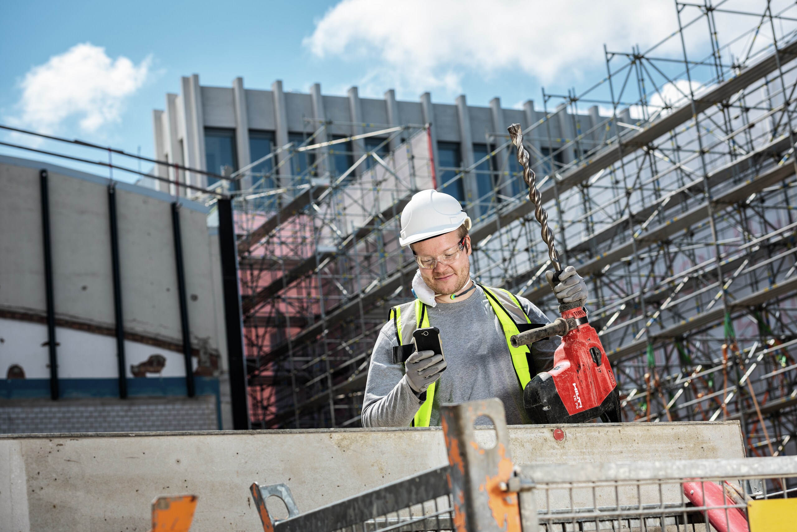 Travaileur en utilisant son mobile sur chantier