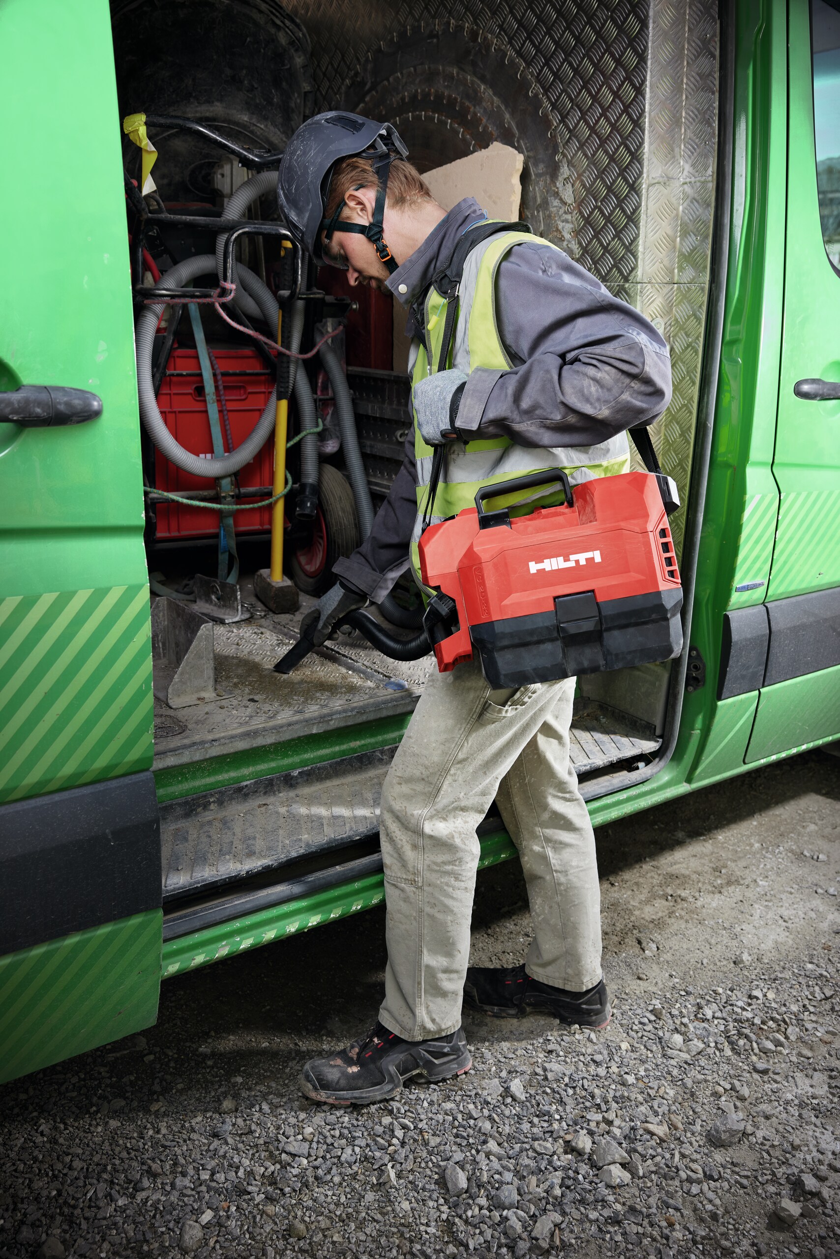 Application picture of a worker cleaning a construction van with the cordless vacuum cleaner VC 2D-22.