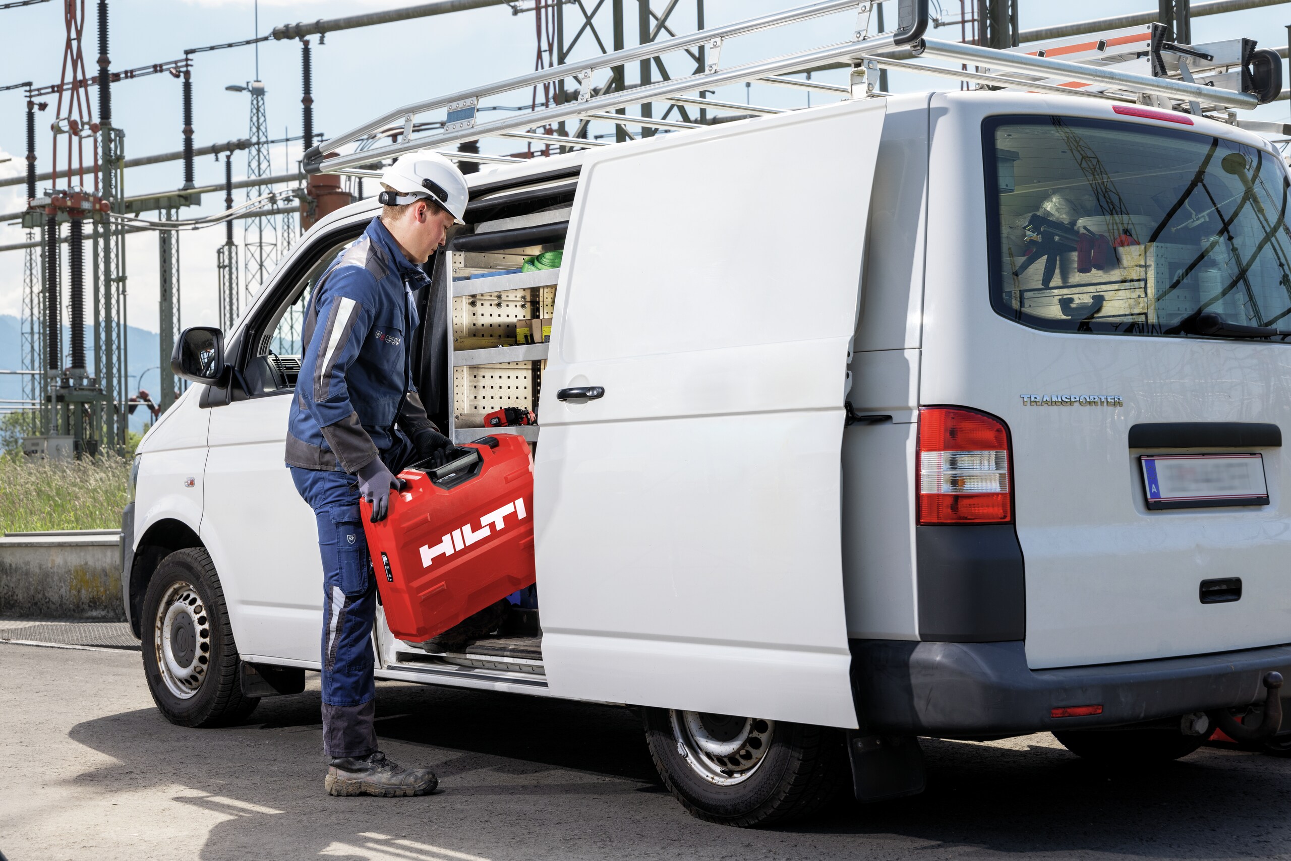 man with a hilti case next to a white van