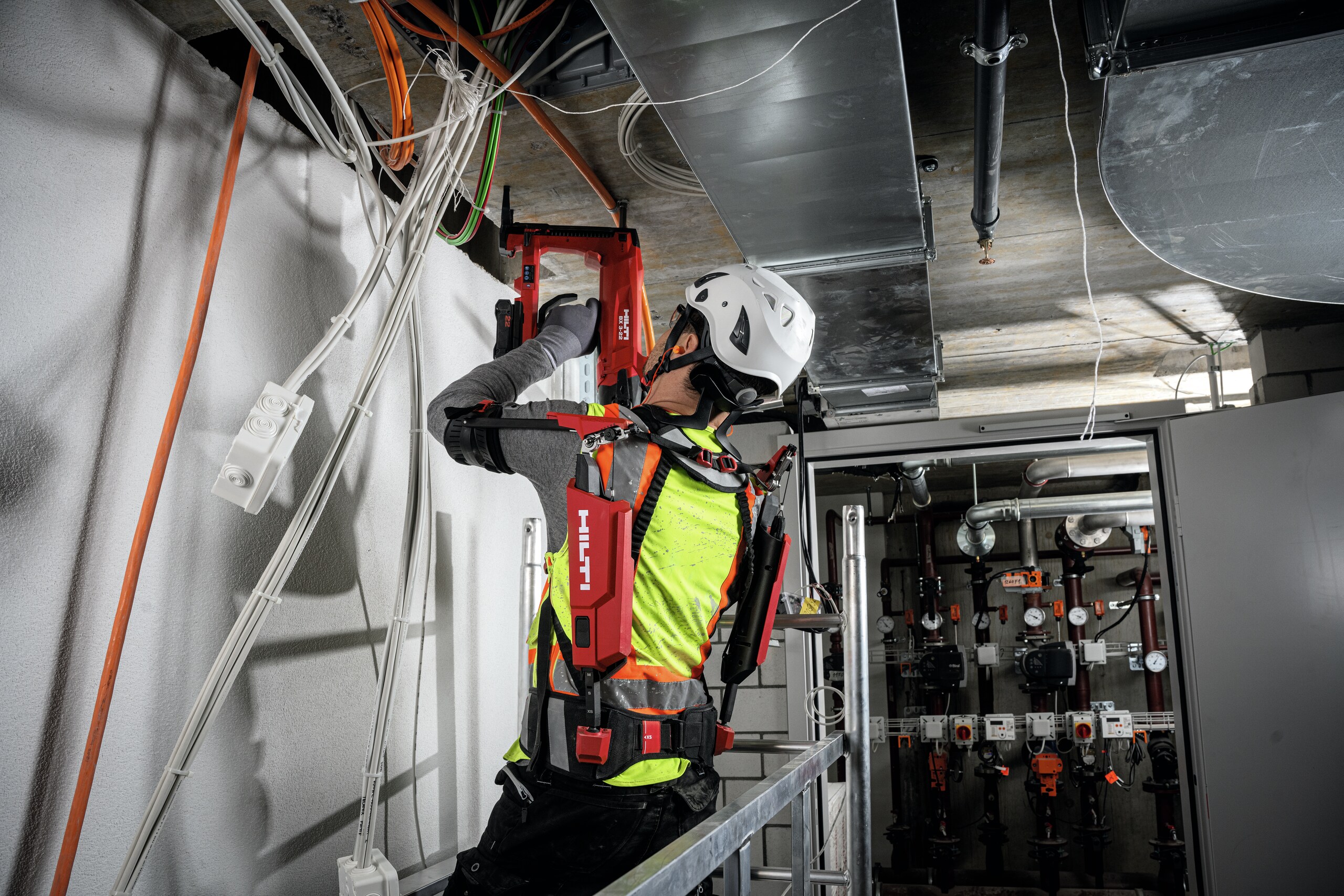 Installing cables, conduits and threaded studs overhead with the concrete nailer BX 3-22.