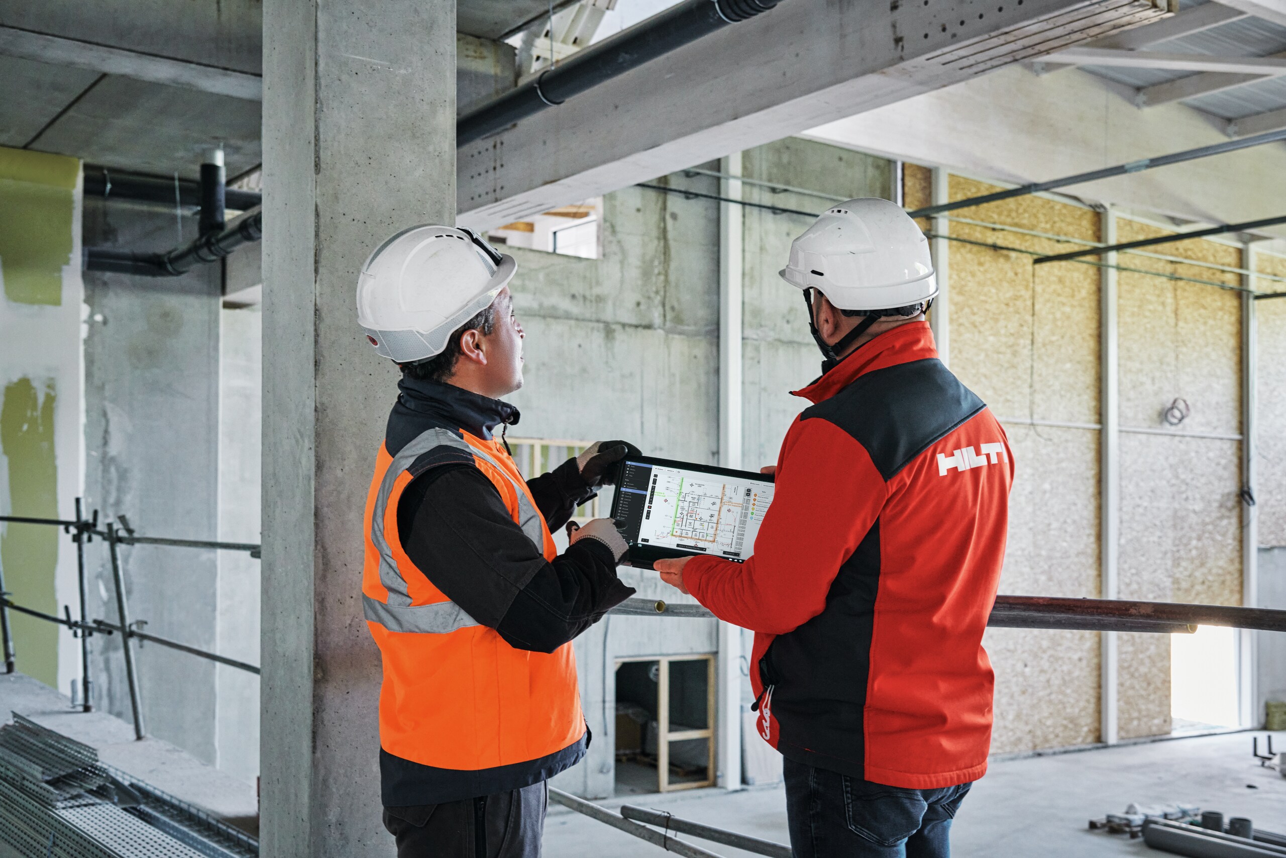 Construction professional and account manager using tablet version of Fieldwire Construction Management software (plan screenshot) on jobsite