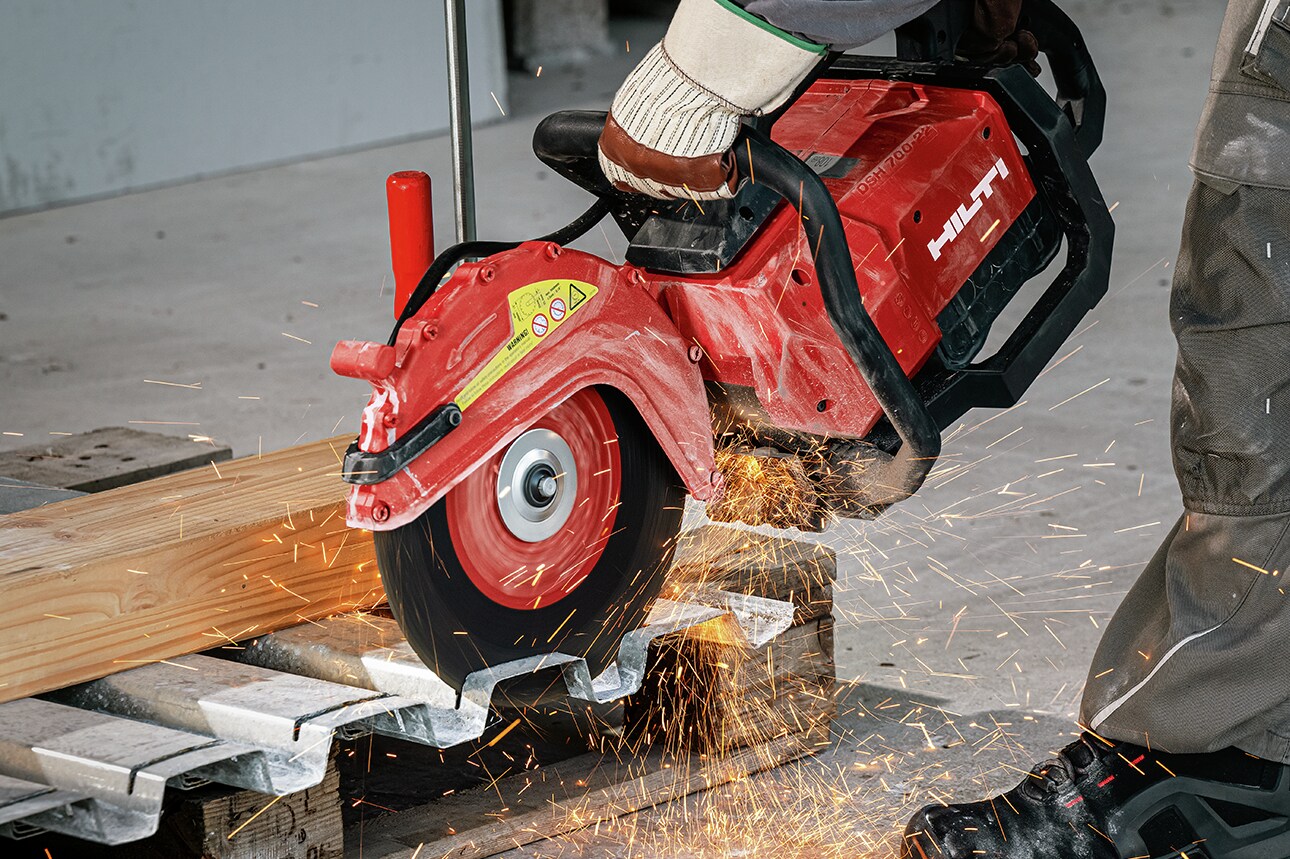 Personne utilisant une découpeuse Hilti pour couper un tube de métal